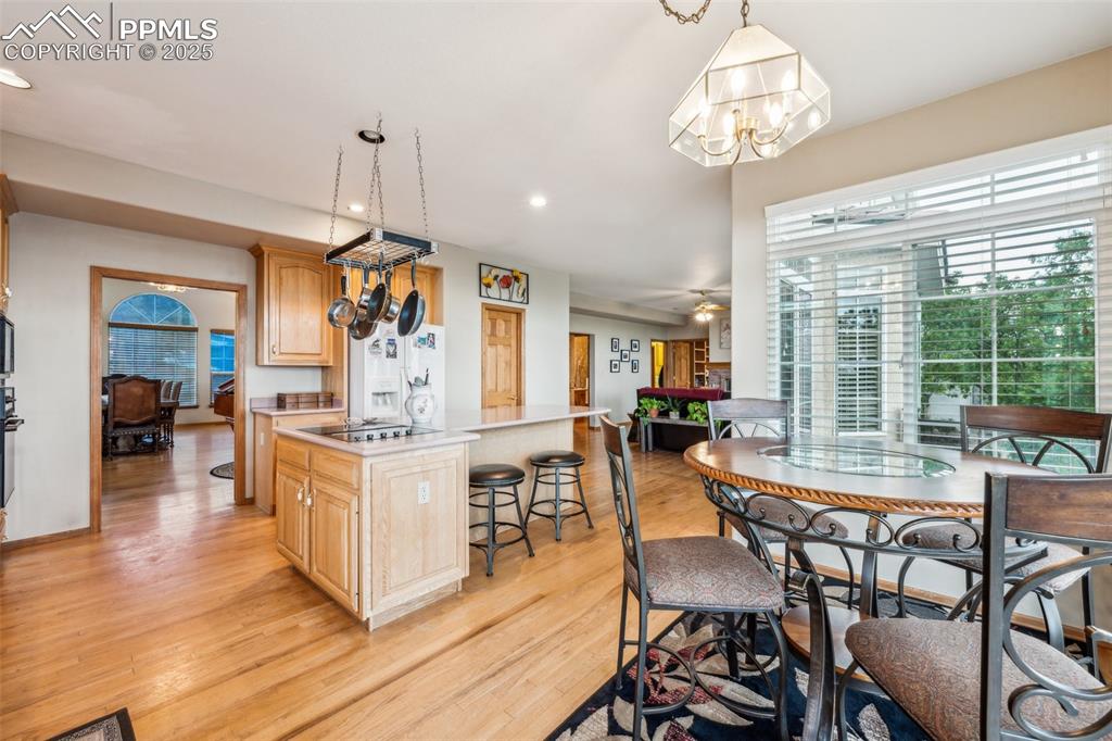 Image 12 of 43: Kitchen featuring a center island, light countertops, light wood flooring,