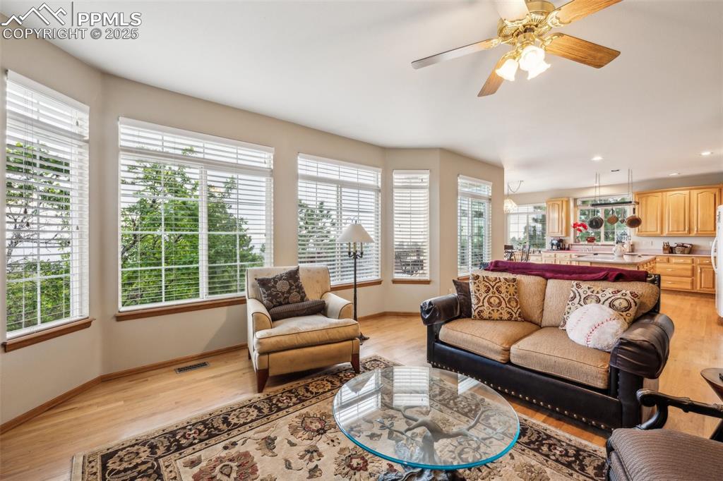 Image 14 of 43: Living room featuring wood flooring, baseboards, a ceiling fan, and recesse