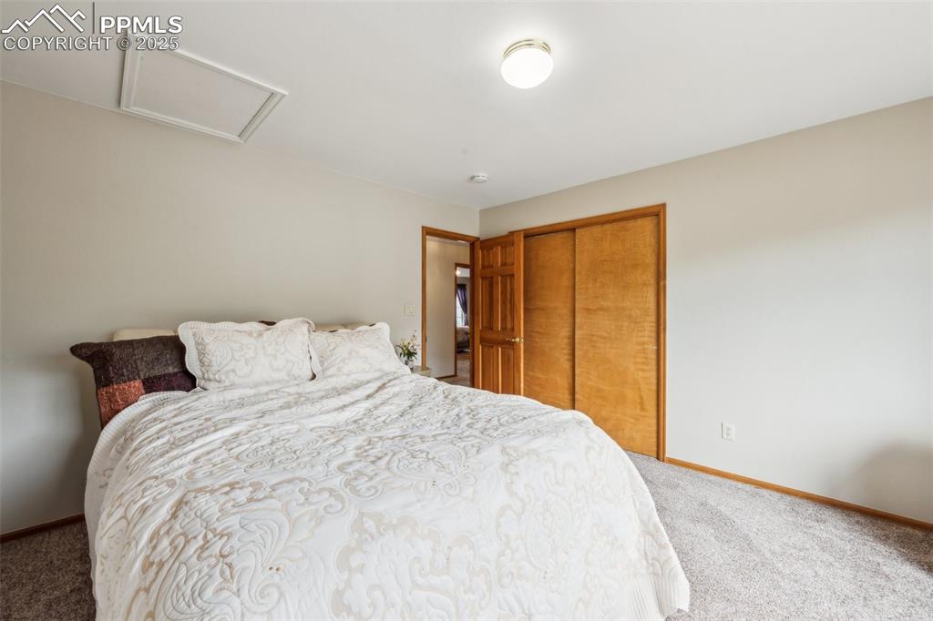 Image 31 of 43: Bedroom with carpet flooring, attic access, a closet, and baseboards