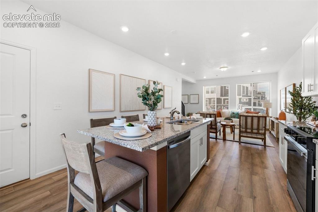 Image 13 of 35: Open concept living space featuring wood-finish flooring throughout, a kitc