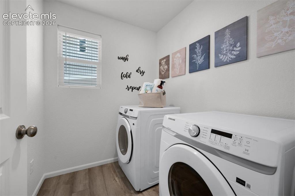 Image 14 of 35: Room featuring a window with blinds, wood-finish flooring, and a white door