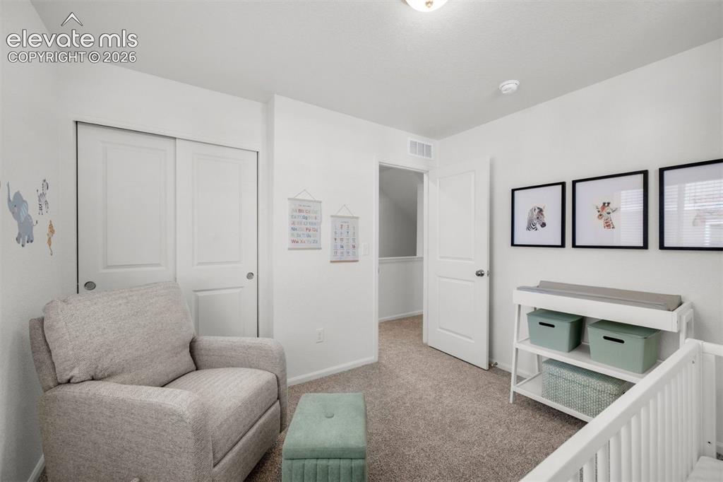 Image 26 of 35: Wall-to-wall carpeting, white interior doors, and a built-in closet with sl