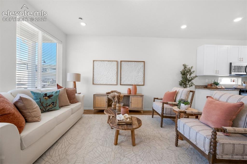 Image 5 of 35: Recessed lighting, wood-finish flooring, white walls, large windows with bl