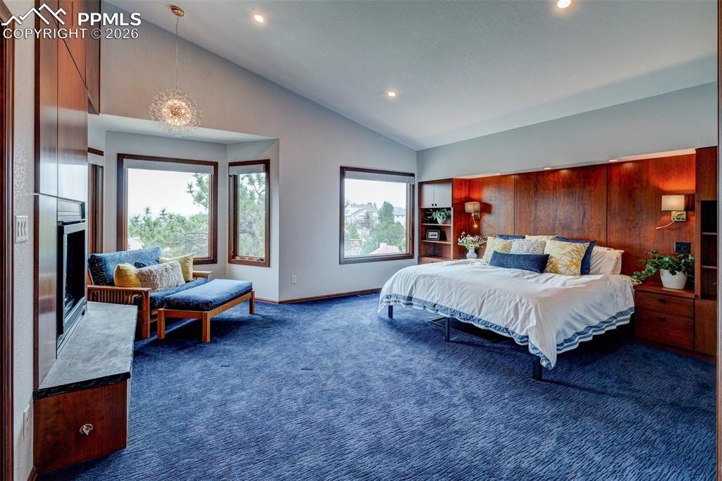 Image 23 of 39: Primary bedroom with custom bed wall and matching fireplace wall