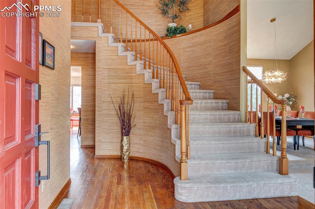 Image 3 of 39: Spacious entry hall with impressive circular staircase
