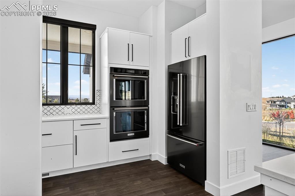 Image 12 of 44: Back kitchen with double ovens and fridge