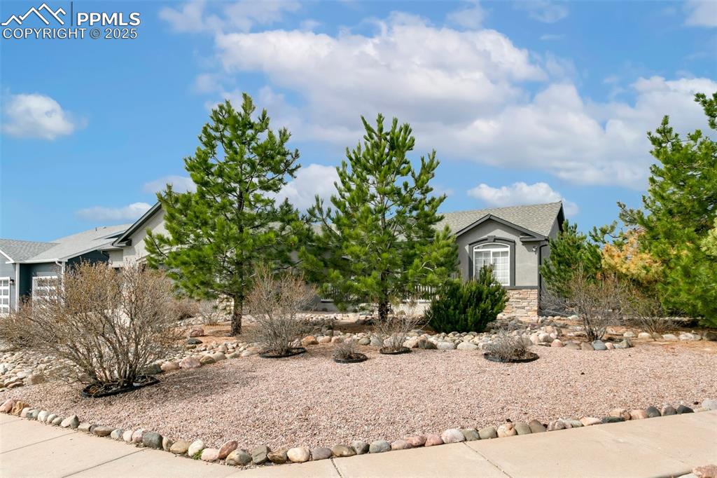 Image 3 of 35: Obstructed view of property featuring stone siding, stucco siding, and a sh