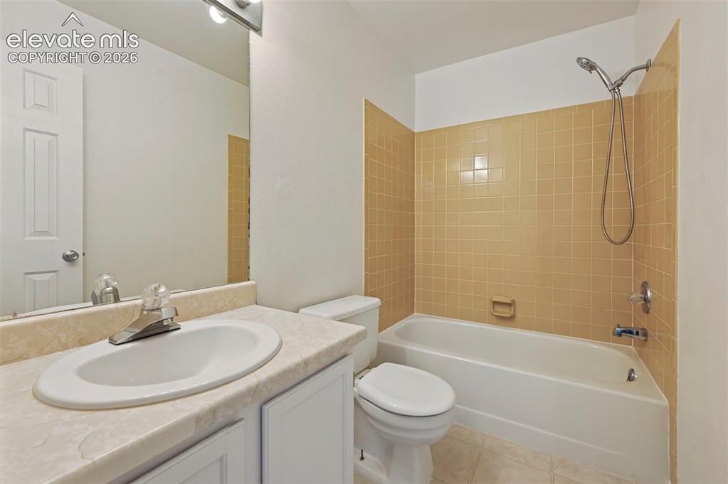 Image 22 of 25: White bathroom vanity with an integrated sink and chrome faucet, set agains