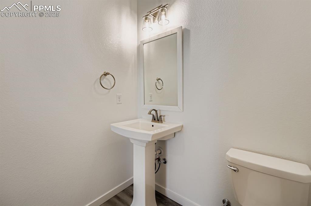 Image 11 of 28: Bathroom with toilet and dark wood-style floors