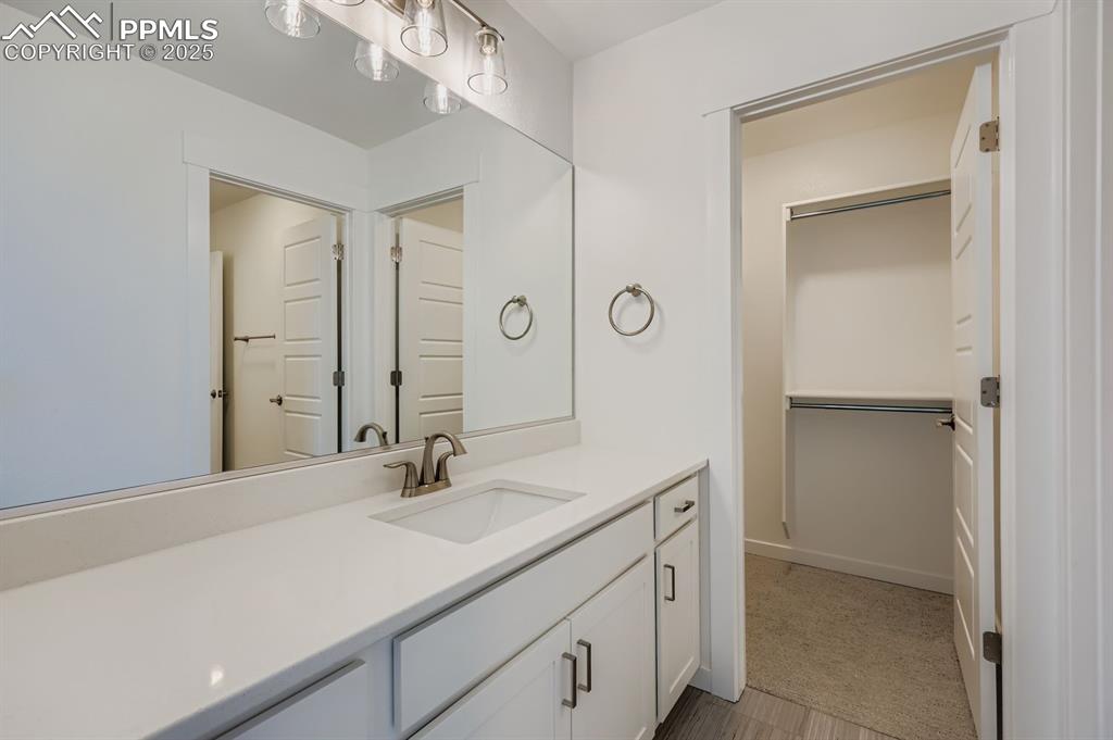 Image 20 of 28: Bathroom featuring vanity and a spacious closet