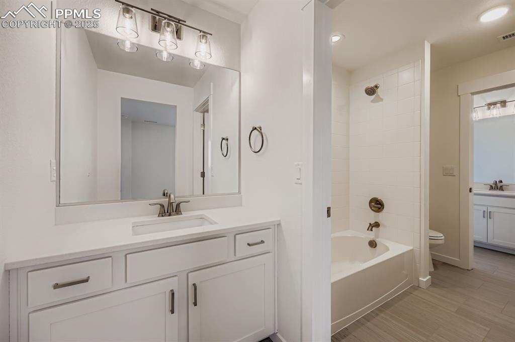 Image 21 of 28: Full bath with vanity, shower / bath combination, and light wood finished f