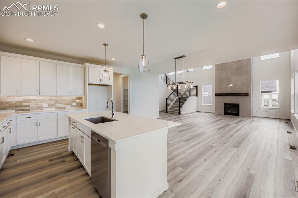 Image 8 of 28: Kitchen featuring hanging light fixtures, white cabinetry, decorative backs