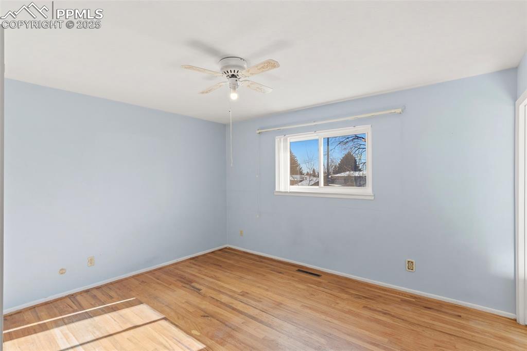 Image 16 of 32: Primary bedroom with original hardwood flooring