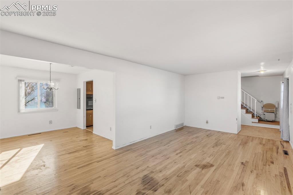 Image 5 of 32: Front Living Room, original hard wood floors need some TLC, but there is lo