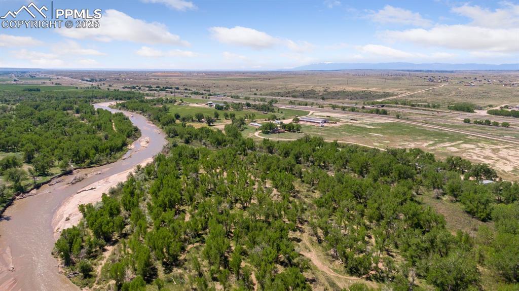 Caption: Aerial view of 165-acre property along Fountain Creek with expansive open land, natural creek corrid