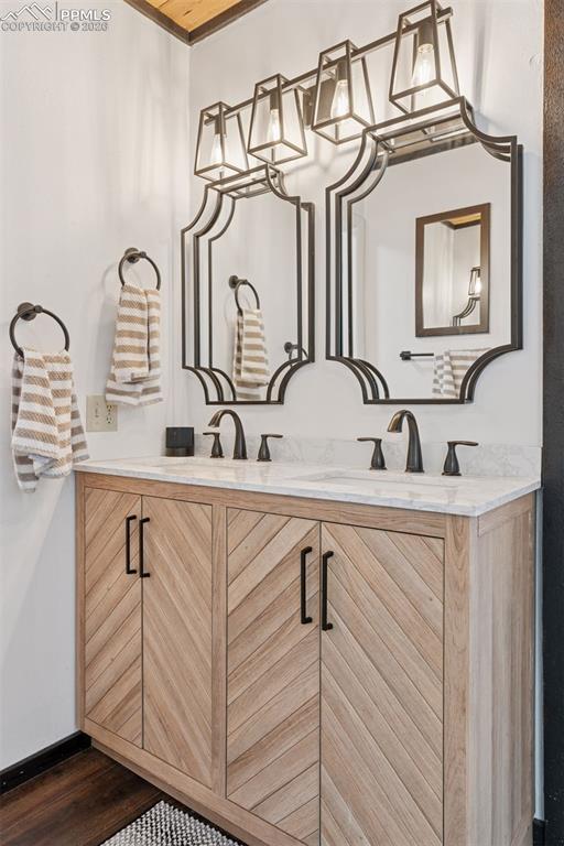 Image 14 of 49: En-suite bathroom with dual sinks, updated vanity cabinetry, and modern lig