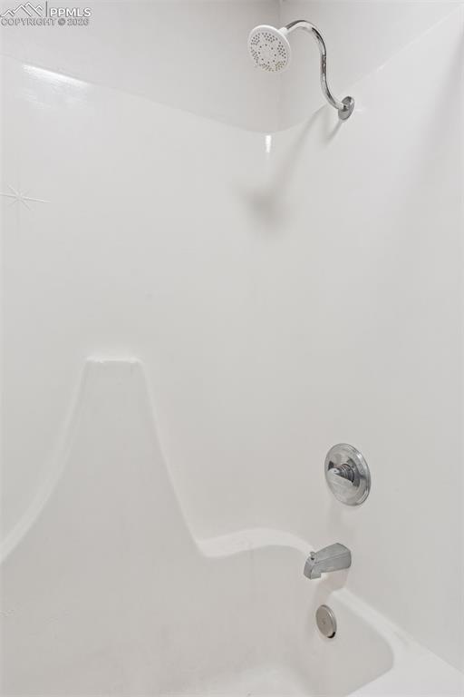 Image 15 of 49: En-suite bathroom shower and tub combination serving the adjacent bedroom