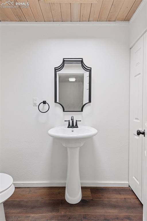 Image 20 of 49: Half bath featuring pedestal sink, mirror, and overhead lighting.