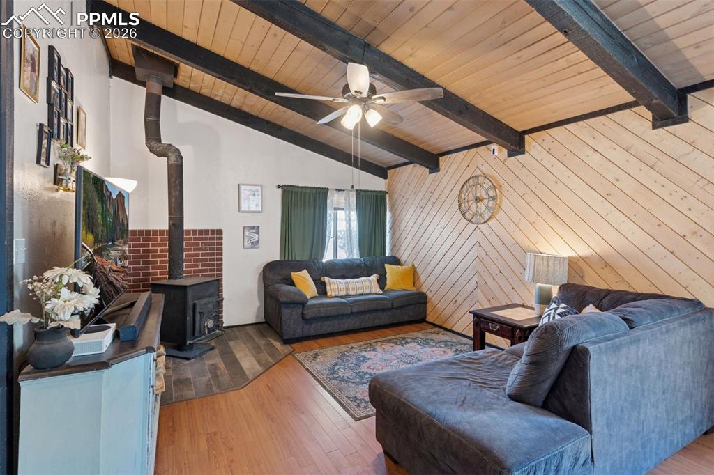 Image 24 of 49: Inviting living room featuring a warm wood-paneled vaulted ceiling, exposed