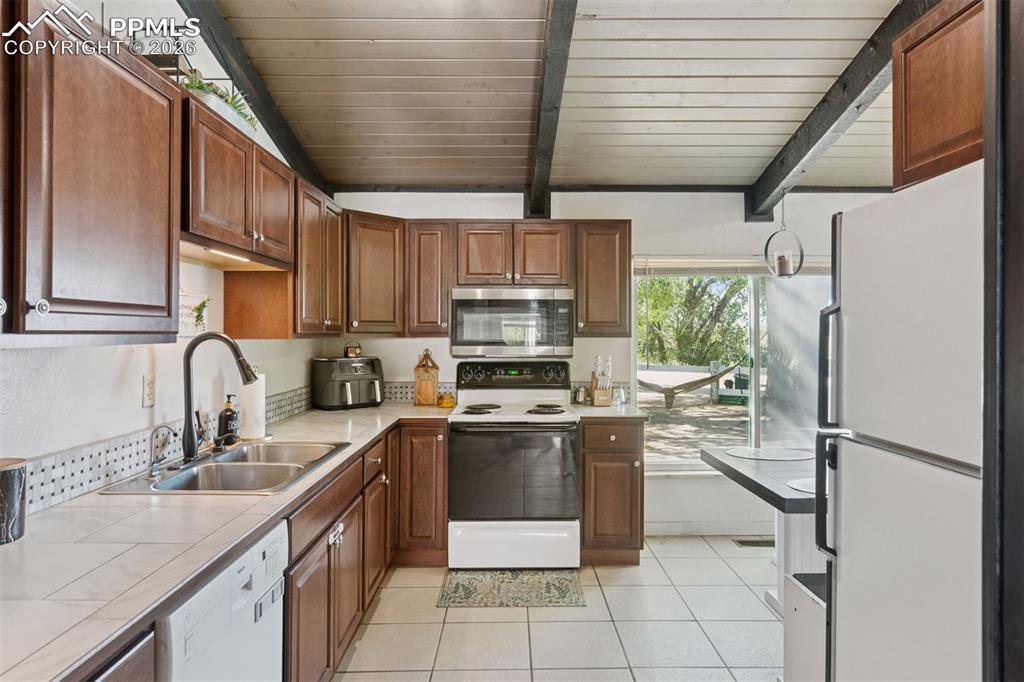 Image 27 of 49: Kitchen featuring ample cabinetry, full appliance package with direct acces