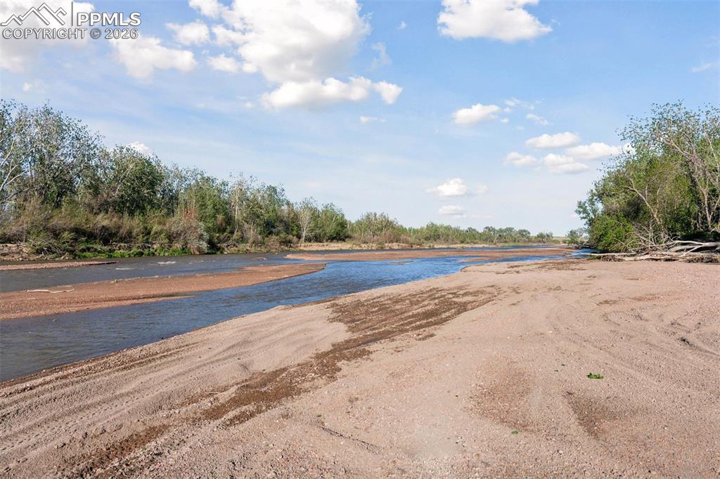 Image 43 of 49: Downstream view of Fountain Creek with seasonal sandbars and riparian green