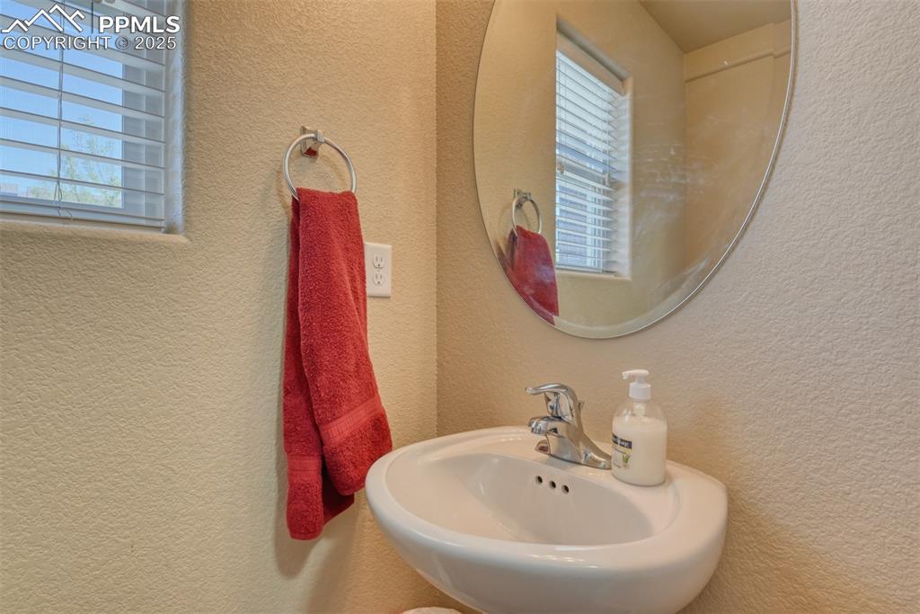 Image 10 of 43: Bathroom featuring a sink and a textured wall
