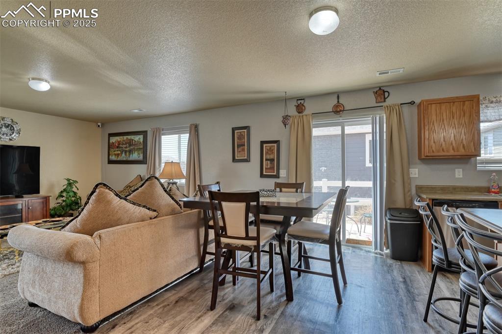 Image 19 of 43: Living area featuring a textured ceiling and wood finished floors