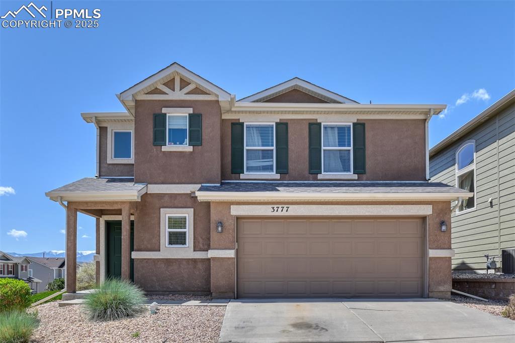 Image 2 of 43: View of front of property with stucco siding, a garage, and concrete drivew