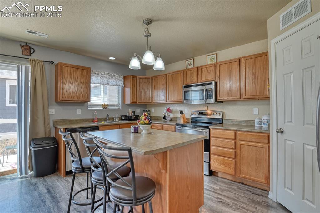 Image 20 of 43: Kitchen featuring stainless steel appliances, light wood finished floors, a