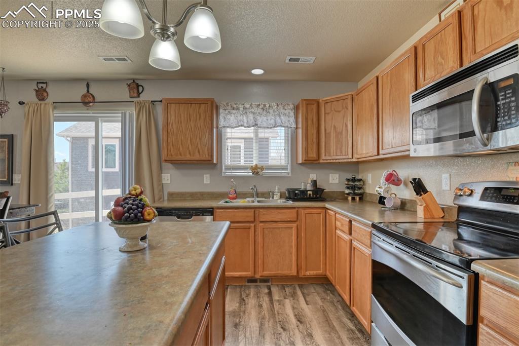 Image 24 of 43: Kitchen with appliances with stainless steel finishes, a textured ceiling,