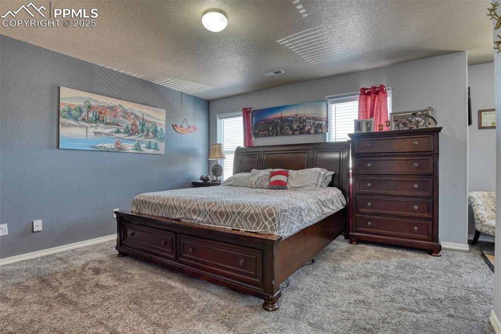 Image 26 of 43: Bedroom featuring a textured ceiling and light colored carpet