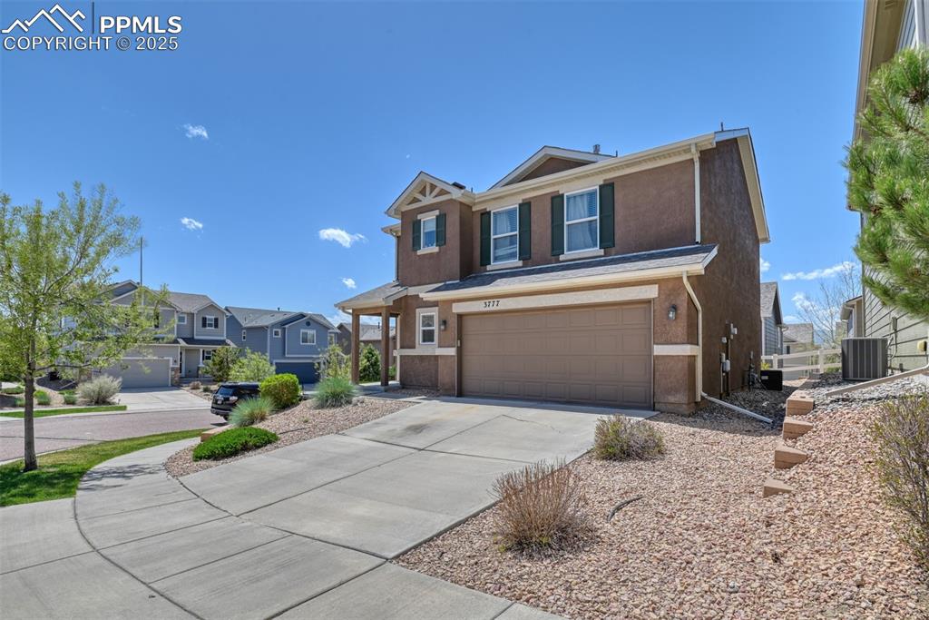 Image 3 of 43: View of front of property with stucco siding, an attached garage, concrete