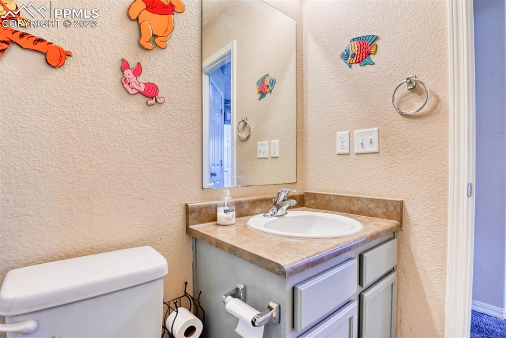 Image 39 of 43: Half bathroom with vanity and toilet