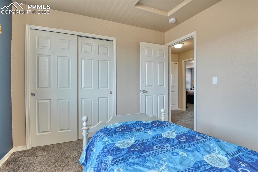 Image 43 of 43: Carpeted bedroom featuring attic access and a closet