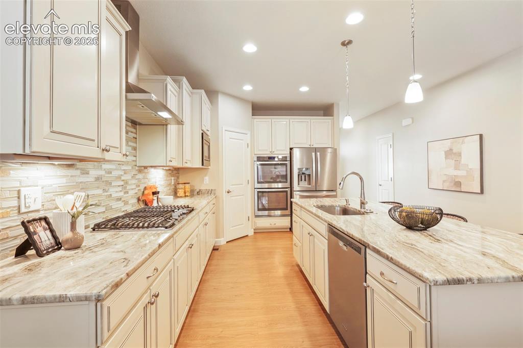 Image 9 of 49: granite surfaces, gas cooktop, double ovens