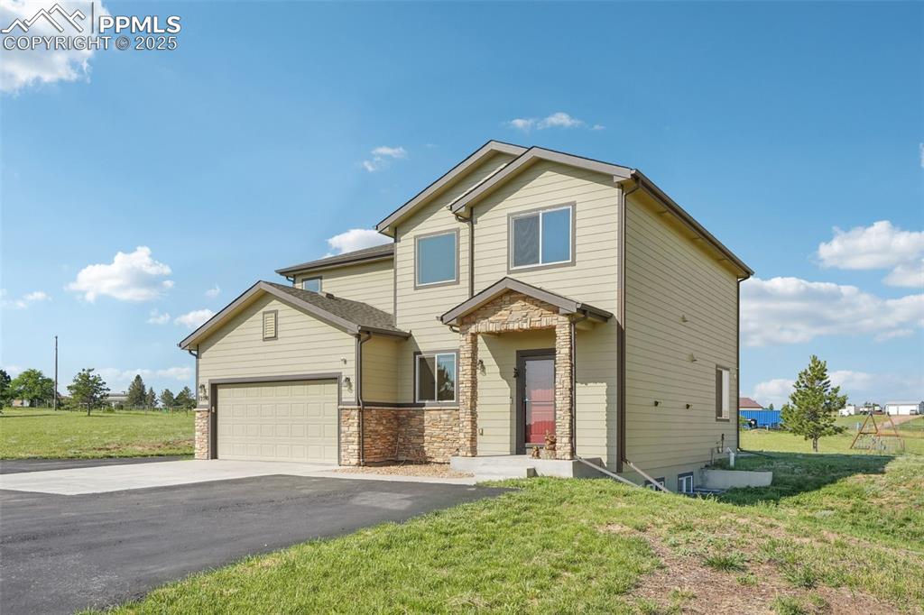 Image 2 of 46: View of front of property with driveway, an attached garage, a front lawn,