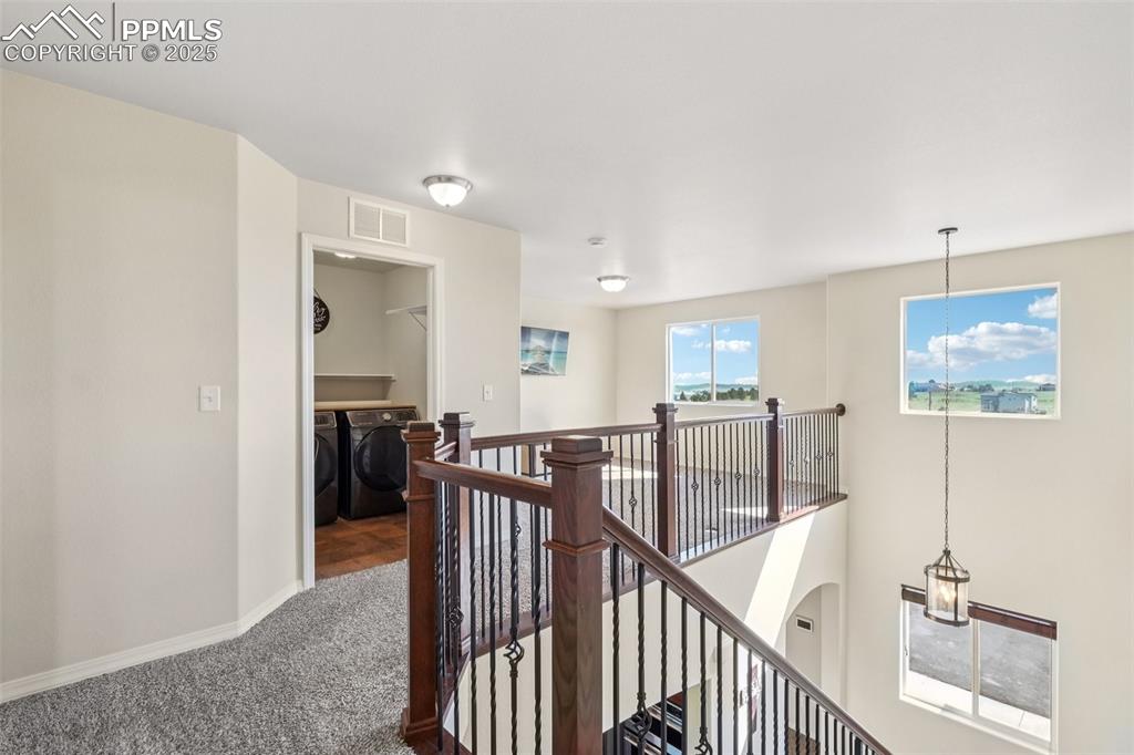 Image 20 of 46: Corridor featuring an upstairs landing, washer and clothes dryer, and carpe