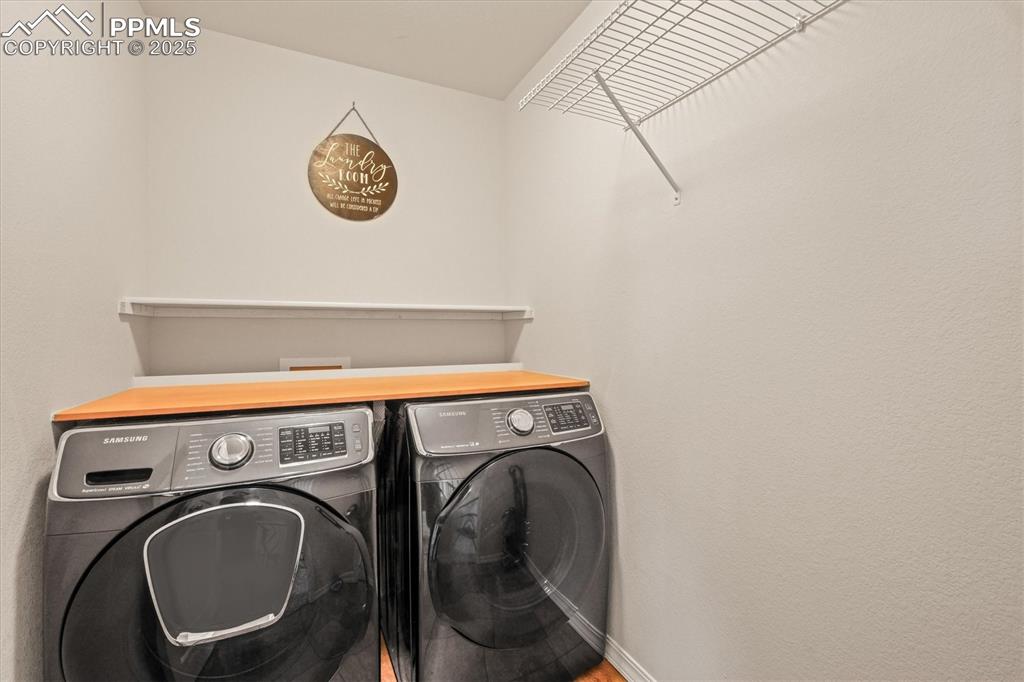 Image 21 of 46: Laundry room with washing machine and dryer, laundry area, and baseboards
