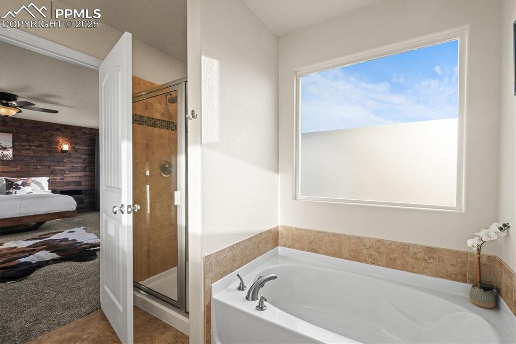 Image 25 of 46: Ensuite bathroom with a garden tub, ensuite bath, a ceiling fan, and a show