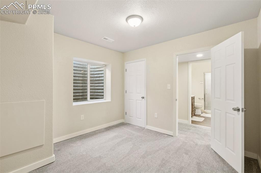 Image 34 of 46: Unfurnished bedroom with carpet and a textured ceiling