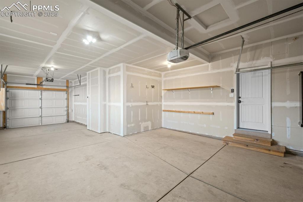 Image 36 of 46: Garage featuring a garage door opener