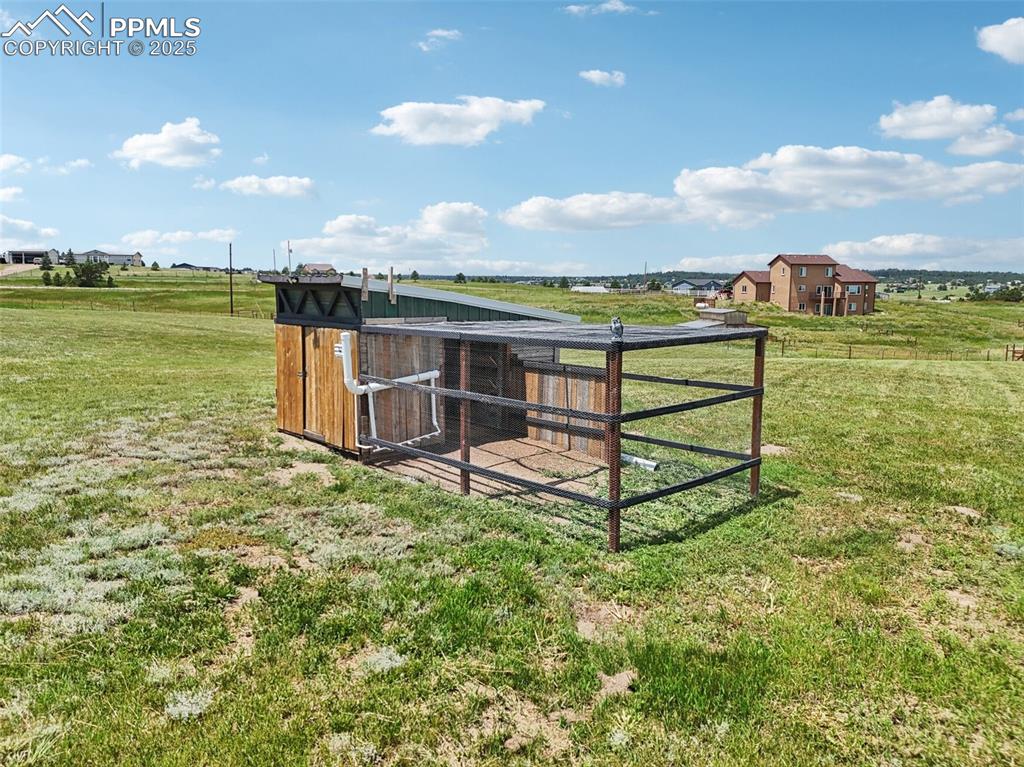 Image 41 of 46: View of grassy yard featuring exterior structure, an outbuilding, and a vie
