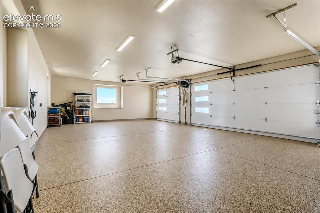 Image 44 of 50: 3 car attached upper garage with epoxy flooring