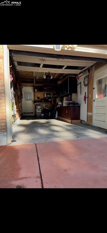 Image 38 of 42: garage with workbench and cabinetry