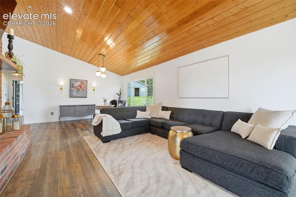 Image 15 of 50: Custom planked ceiling accents the classic brick fireplace
