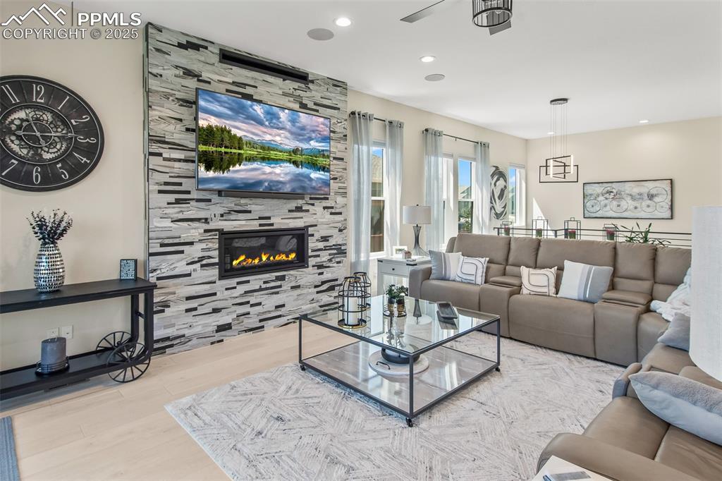 Image 11 of 48: Living area featuring wood finished floors, a tile fireplace, and recessed