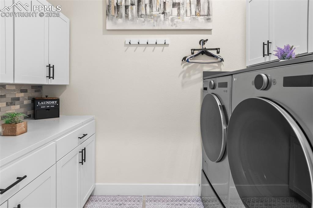 Image 26 of 48: Laundry area featuring cabinet space, light tile patterned flooring, and wa