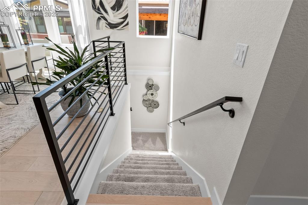 Image 35 of 48: Staircase featuring a textured wall, plenty of natural light, and carpet fl