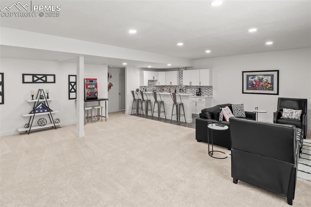 Image 37 of 48: Living area featuring recessed lighting, bar area, and light colored carpet
