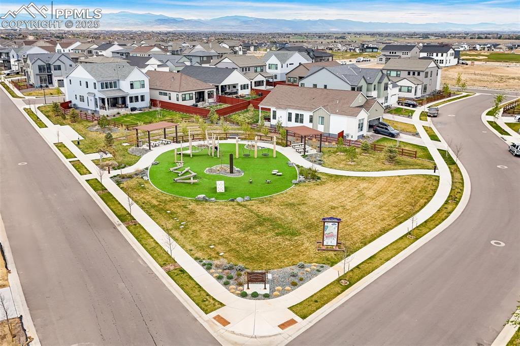 Image 47 of 48: Aerial view of residential area with a mountain backdrop and a recreational